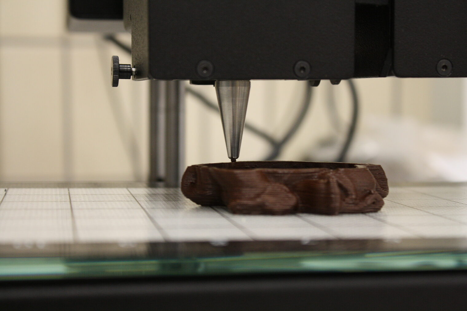 Ein 3D-Lebensmitteldrucker druckt Schokolade.