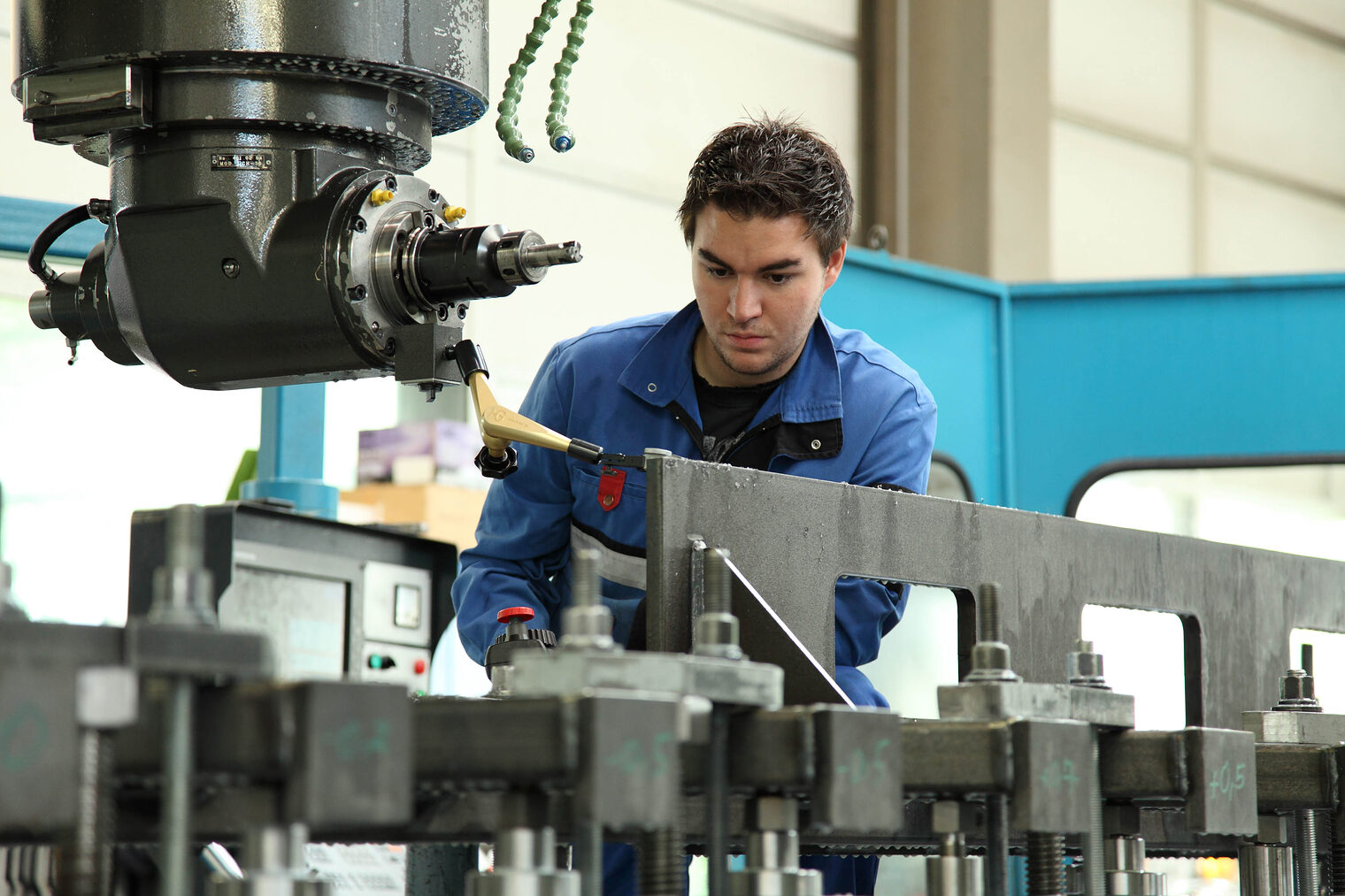Junger Metallbauer bei seiner Arbeit an der Maschine 