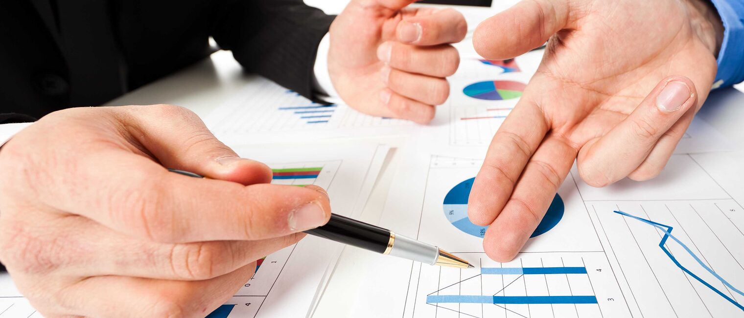 Drei Hände deuten auf verschiedene Diagramme, Business Meeting Symbolbild