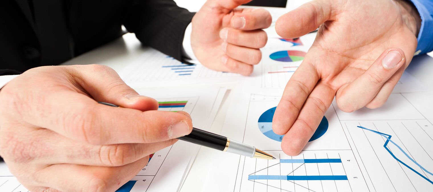 Drei Hände deuten auf verschiedene Diagramme, Business Meeting Symbolbild 