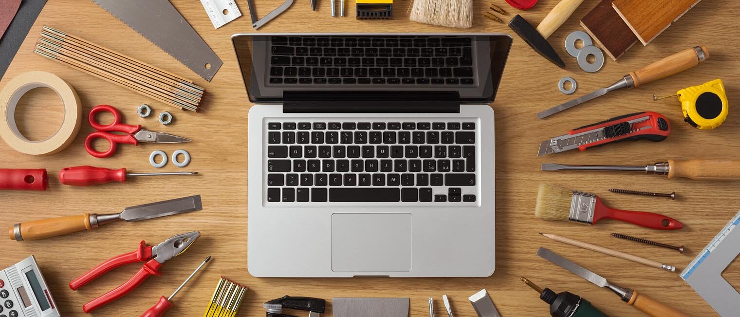 Laptop mit Werkzeug auf Schreibtisch 