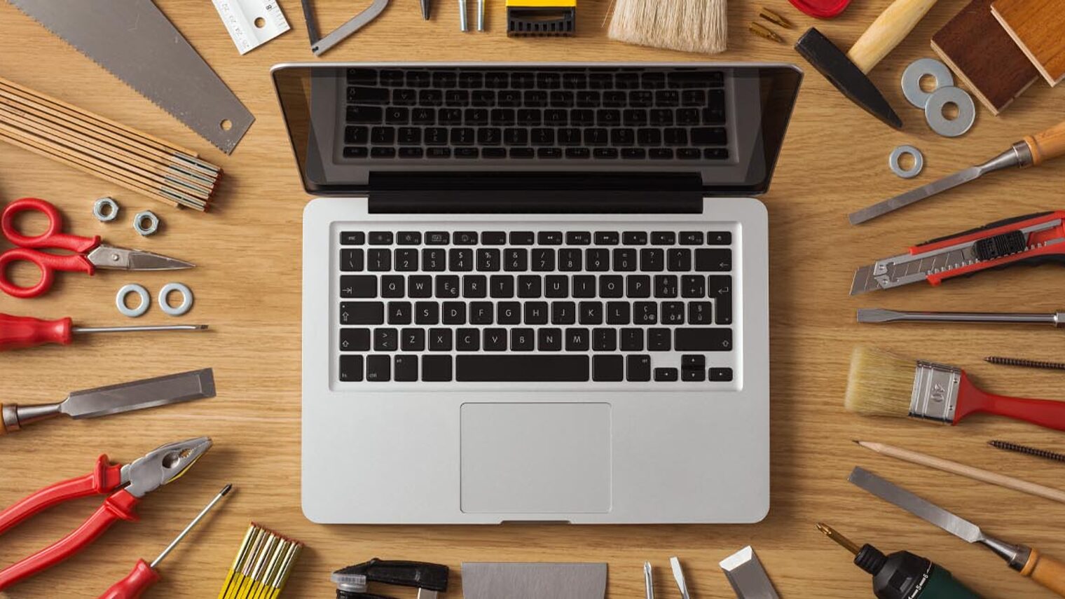 Laptop mit Werkzeug auf Schreibtisch 