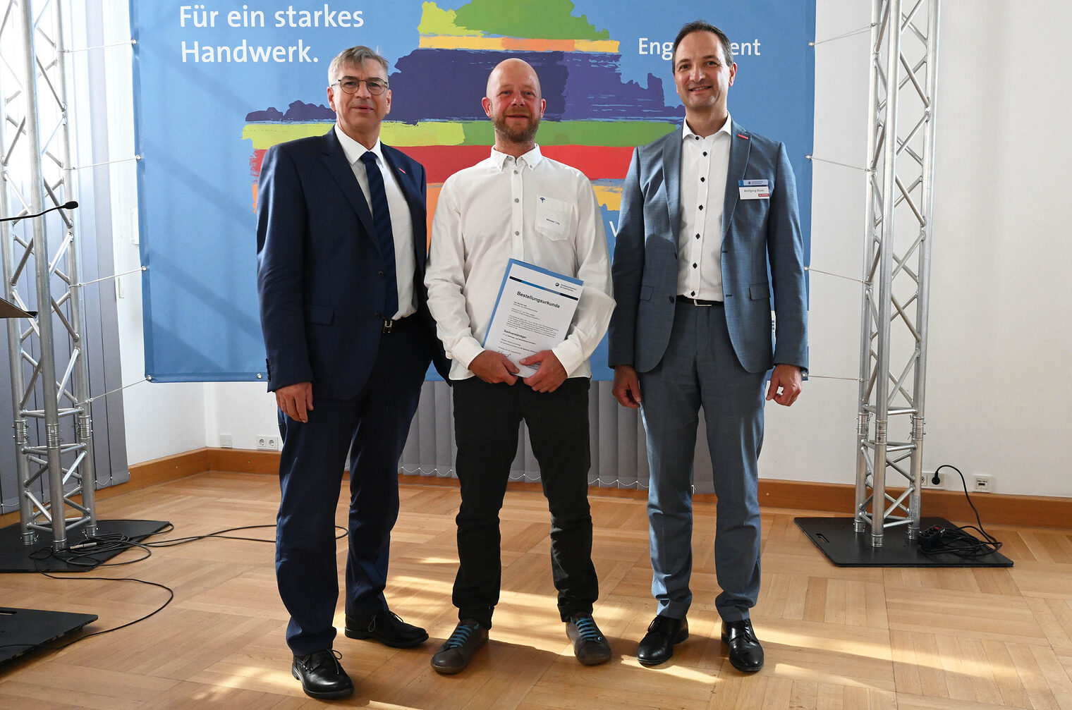 Gruppenfoto von Ehrungsveranstaltung mit drei Personen
