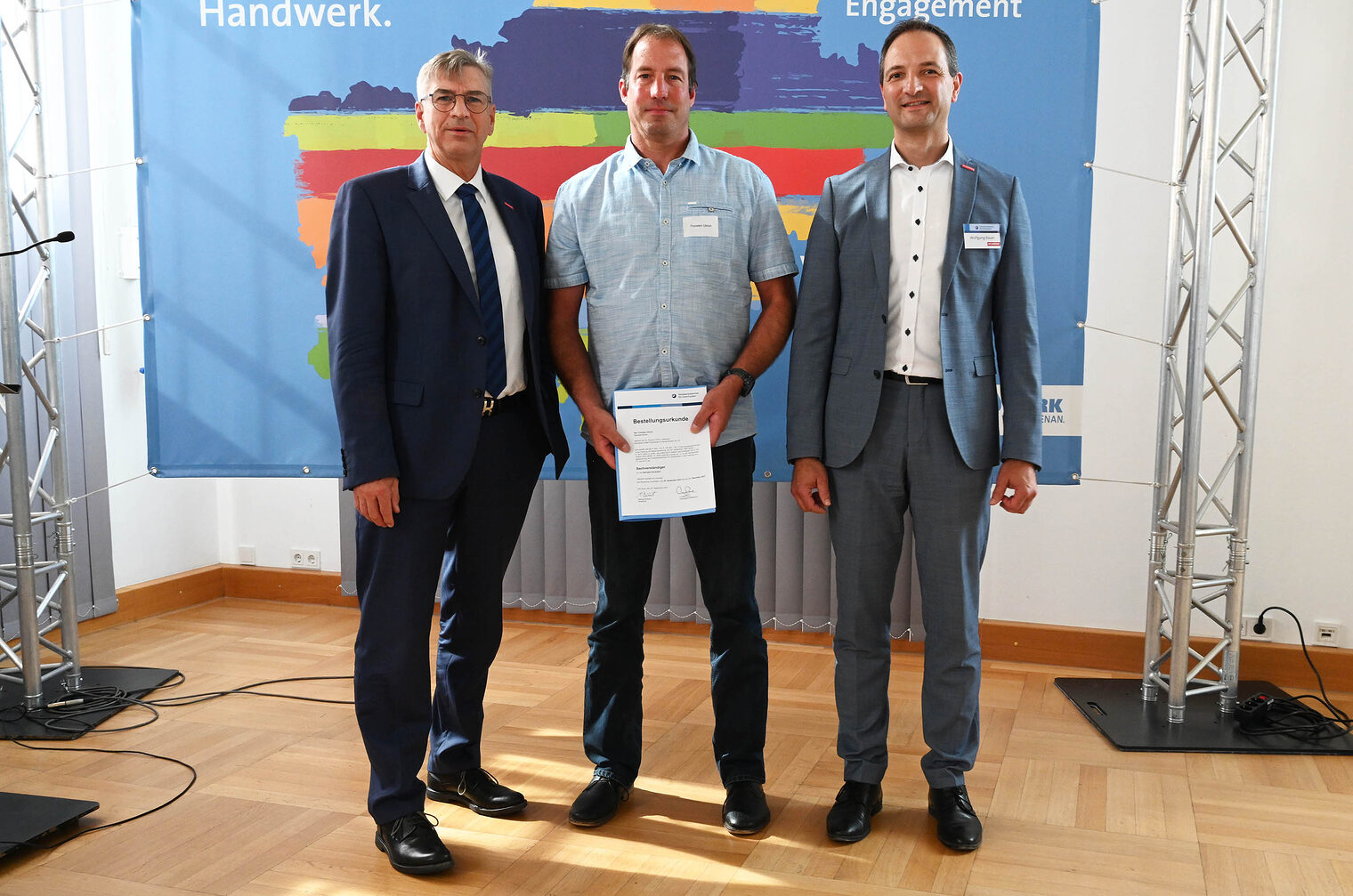 Gruppenfoto von Ehrungsveranstaltung mit drei Personen