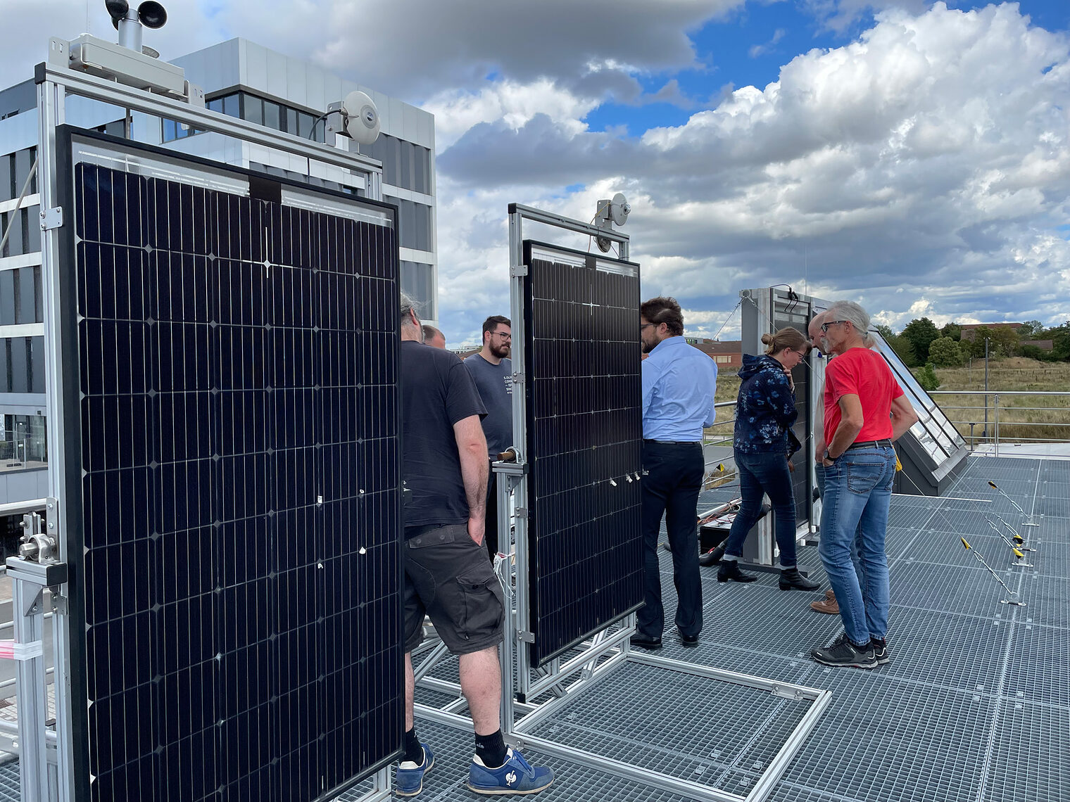 Gruppe auf Dach schaut sich Solarmodule an
