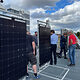 Gruppe auf Dach schaut sich Solarmodule an