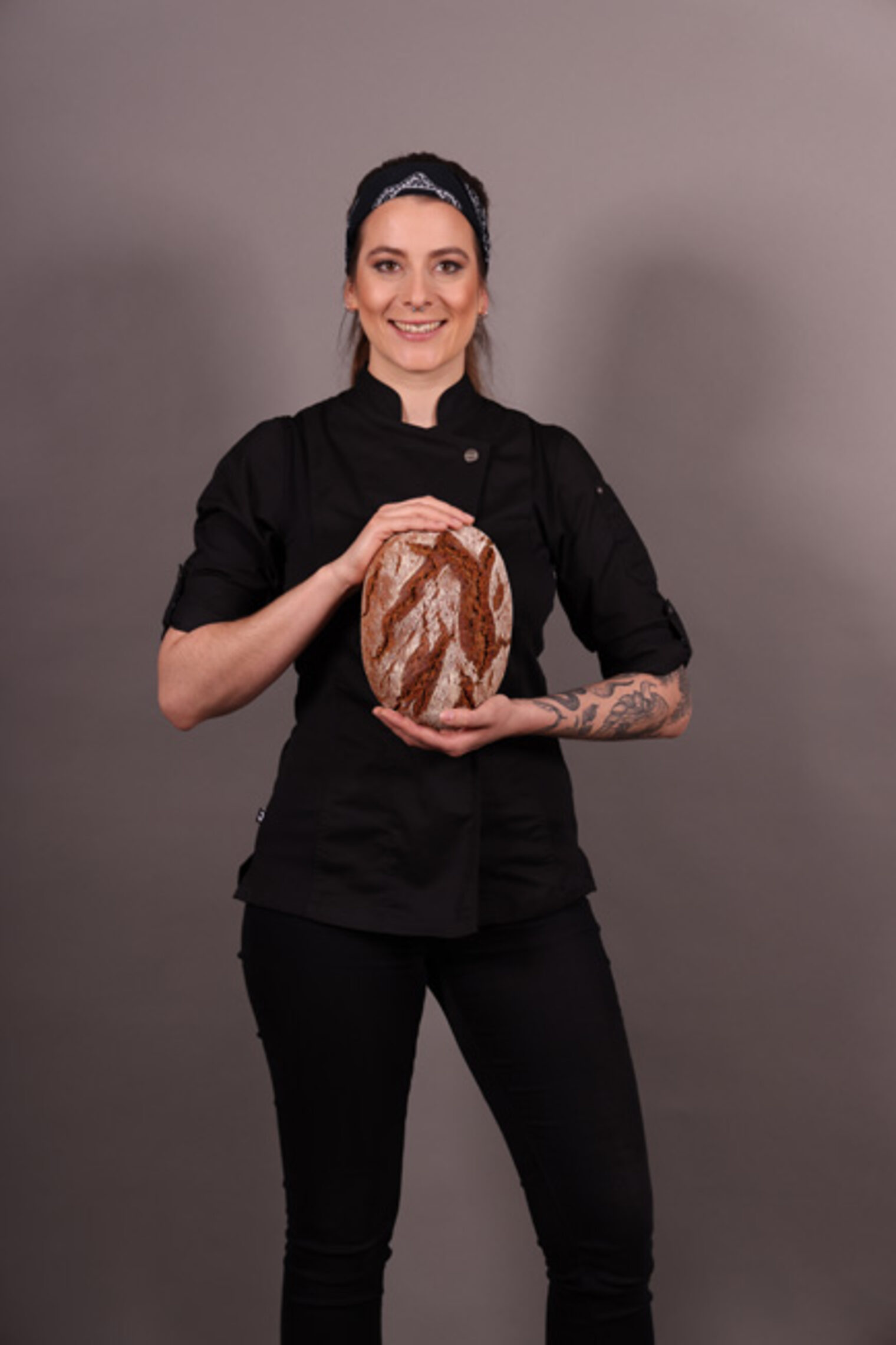 Portraitfoto Bäckerin hält Brot in der Hand