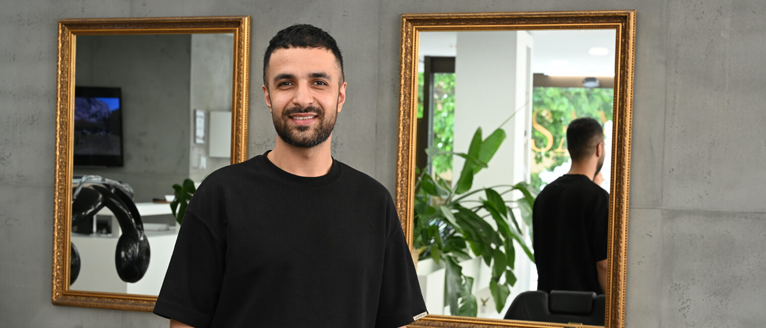 Friseurmeister in einem Salon schaut in Kamera