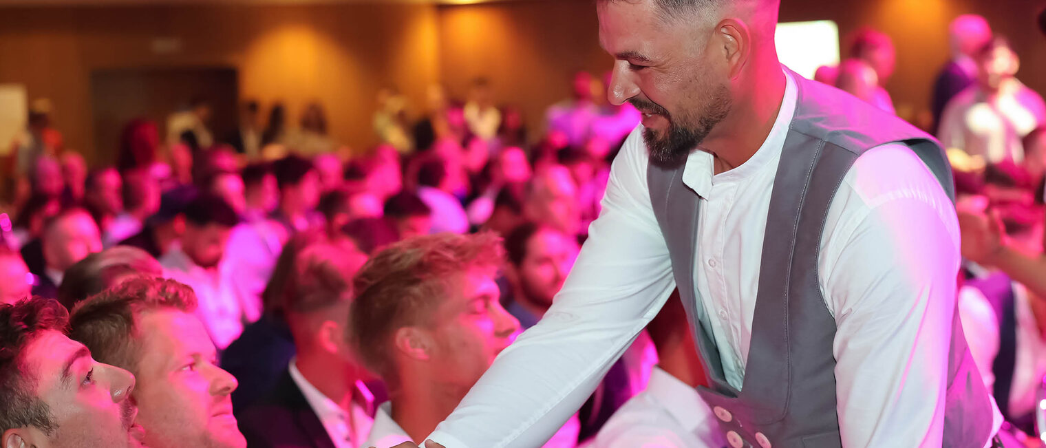 Meister begrüßt Kollegen im Saal
