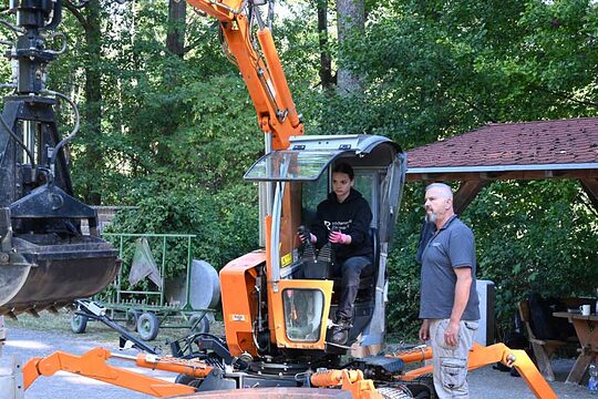 Auszubildende auf Bagger, Dozent leitet an