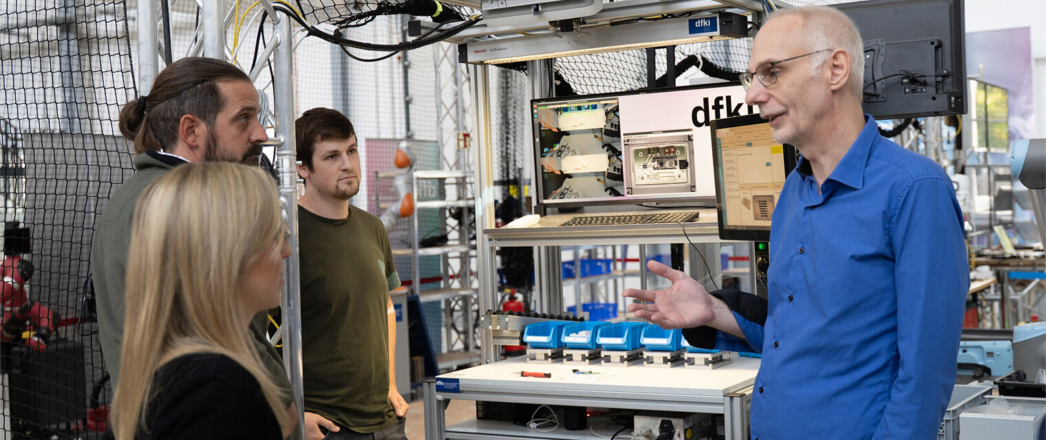 Labor mit Computer und Tracking-Ki-Aufbau, eine Person erklärt drei anderen etwas