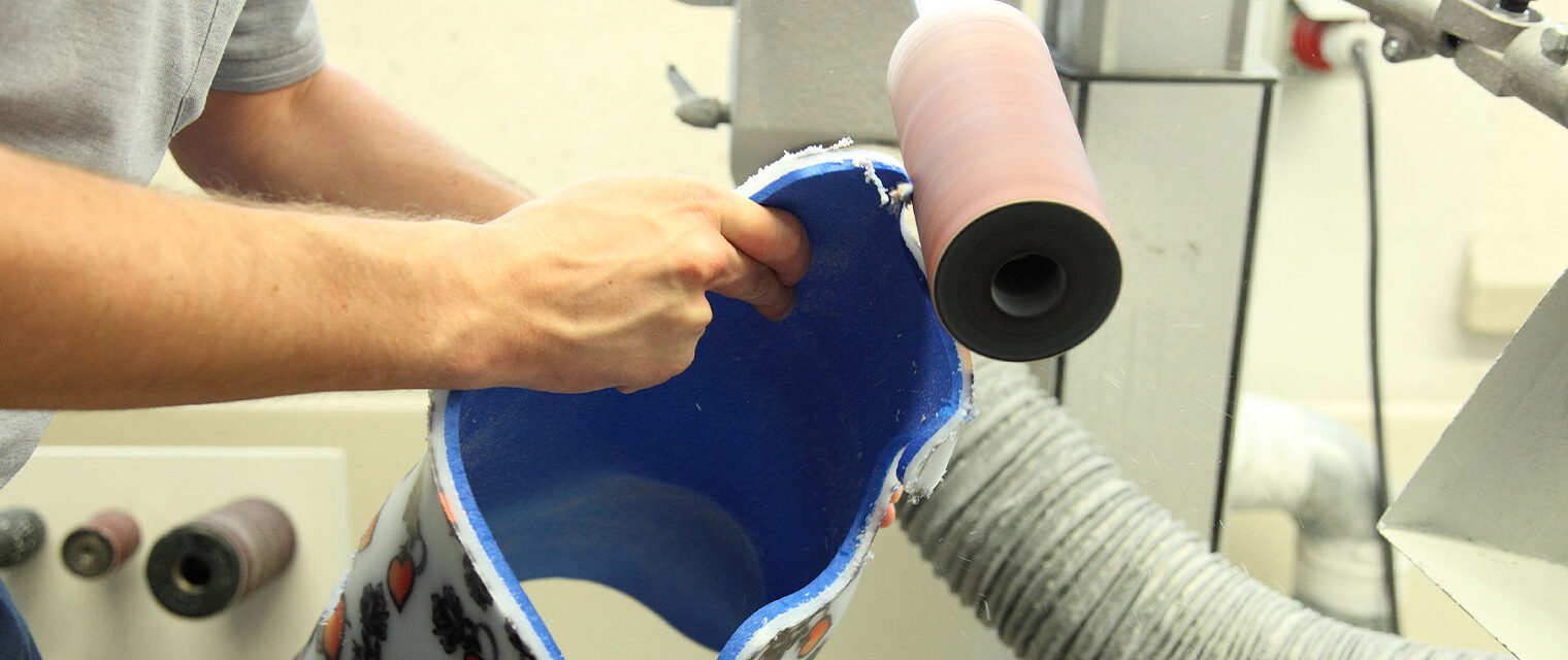 Nahaufnahme Hand mit Prothese an Schleifmaschine