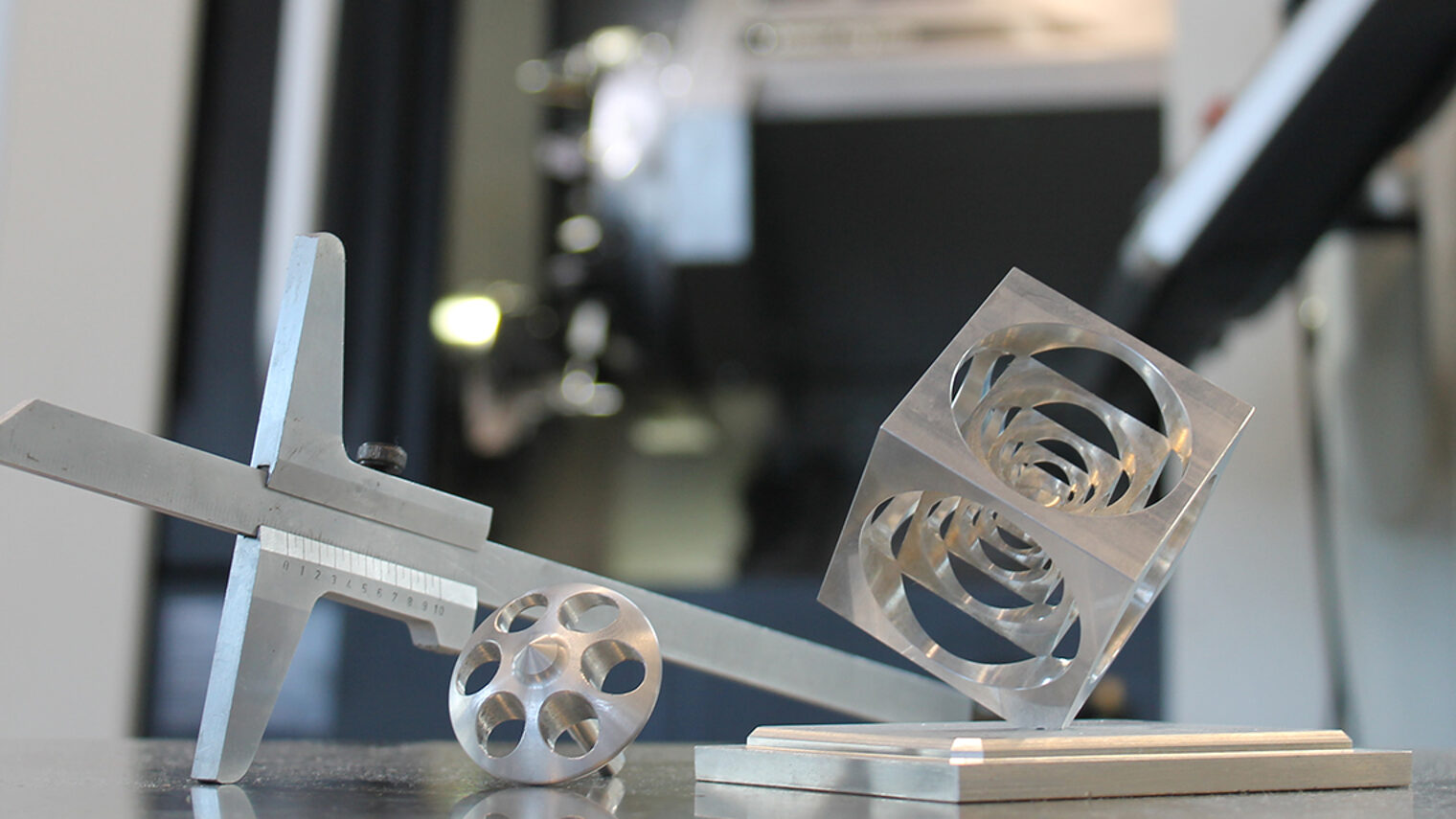Präzisionsarbeit im Meisterkurs: Messschieber, gefräste und gedrehte Metallstücke vor moderner Drehmaschine