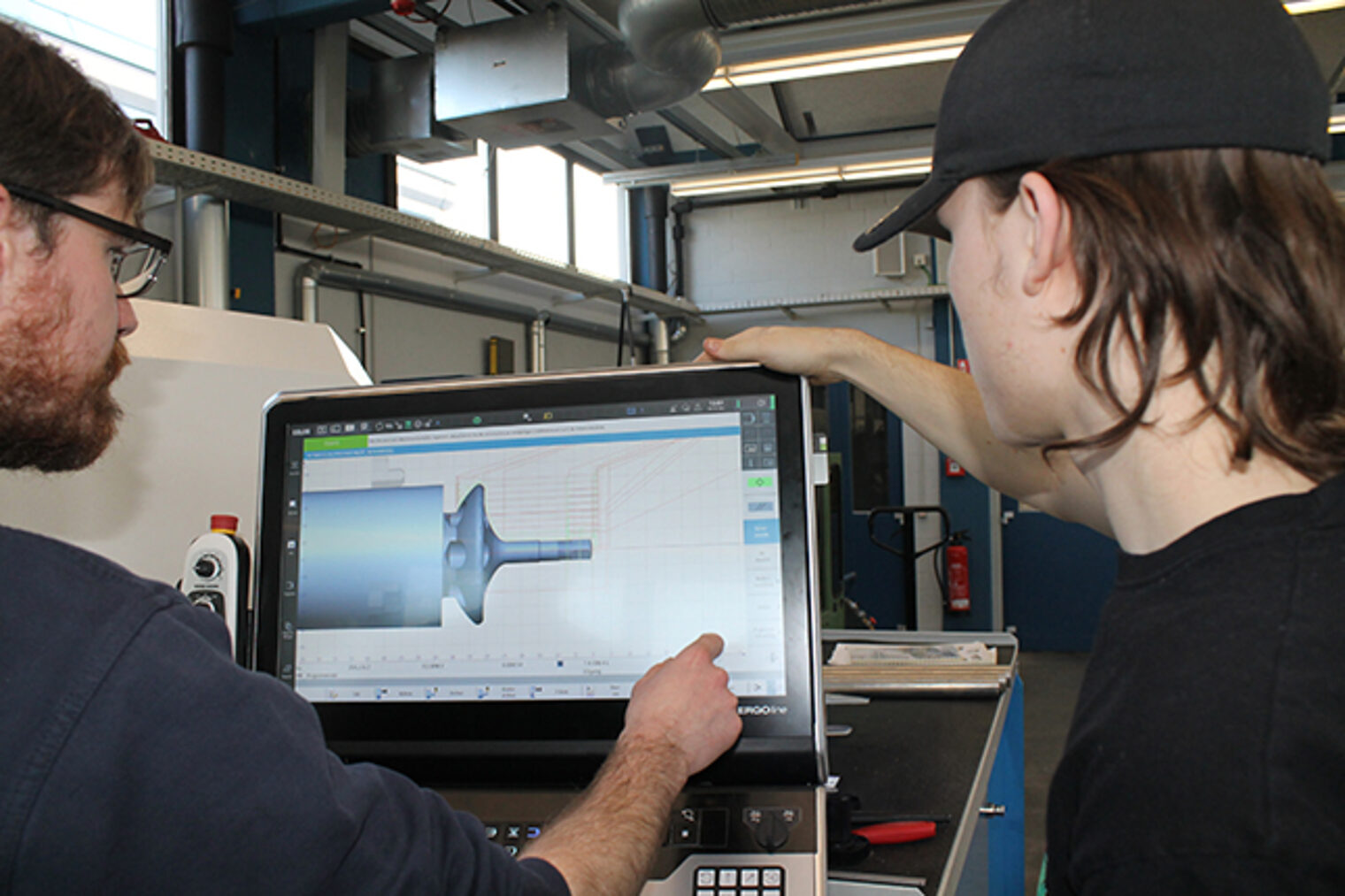 Dozent betreut Schüler beim Einstellen einer Drehmaschine im Meisterkurs Feinwerkmechanik im Bildungszentrum Aschaffenburg