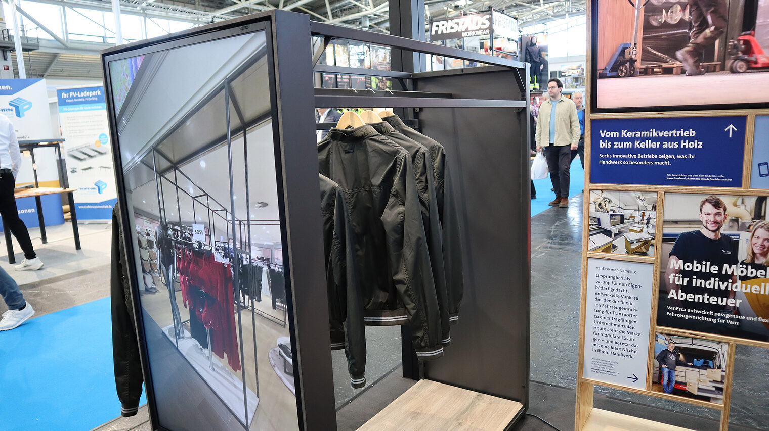 Blick auf Ladenregal mit Bildschirm und Jacken.