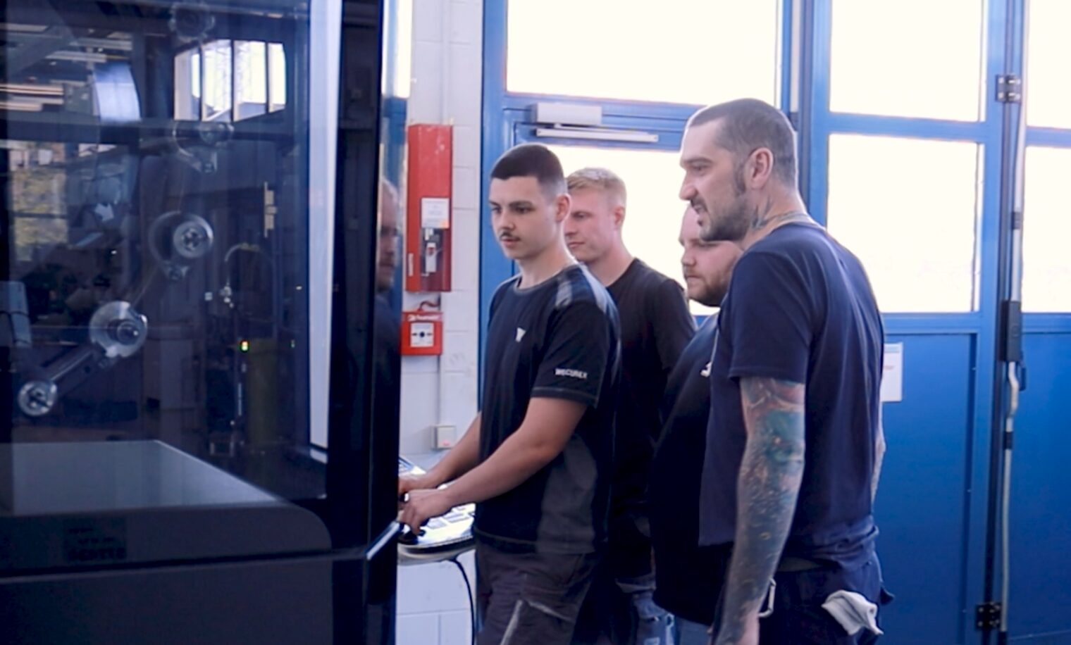 Schüler im Meisterkurs Feinwerkmechanik arbeiten gemeinsam mit Ausbilder an der CNC-Fräsmaschine im Bildungszentrum Aschaffenburg