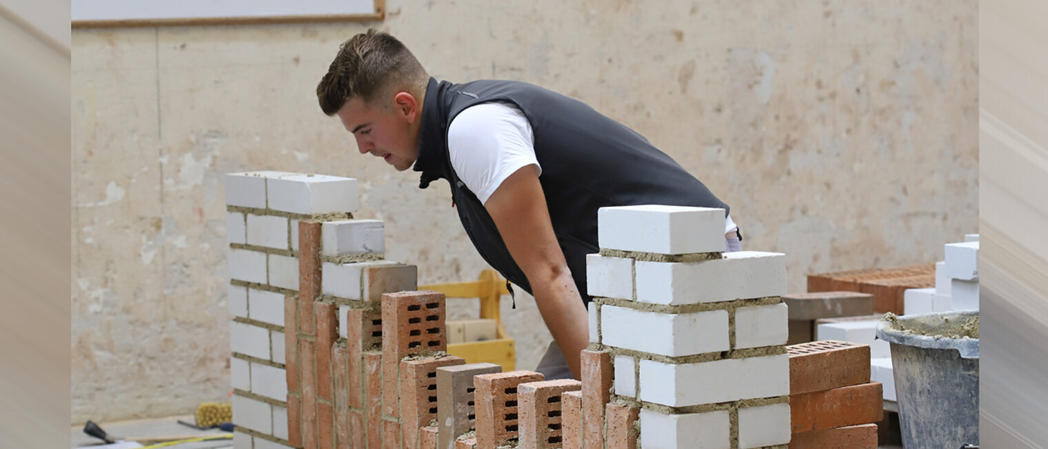 Maurer arbeitet an einer Mauer