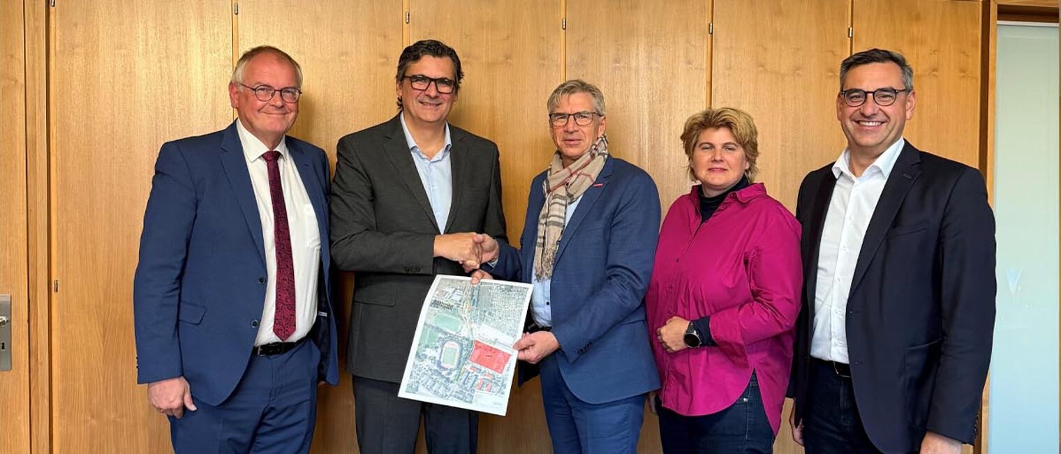 Gruppenfoto mit fünf Personen und Handschlag