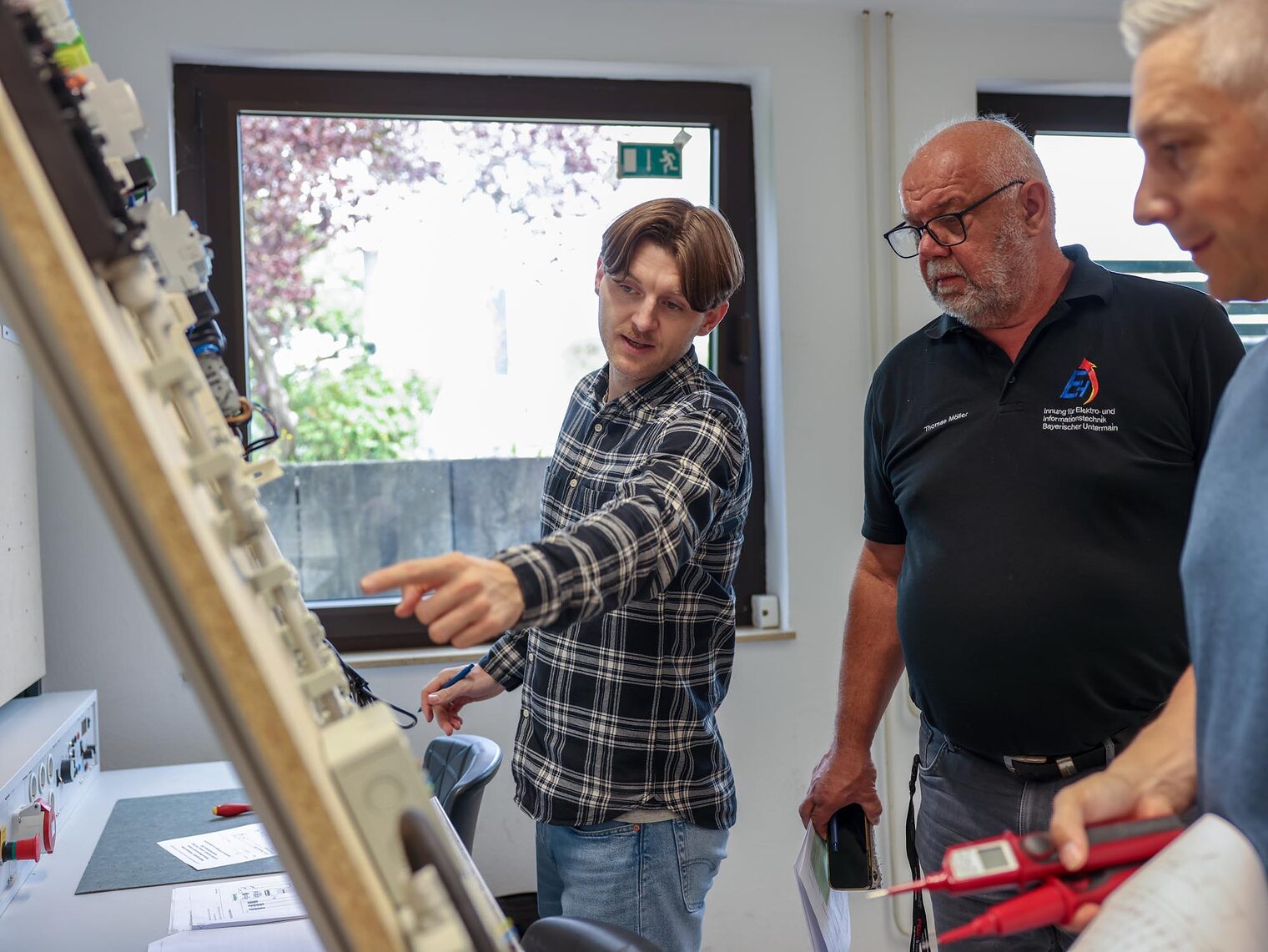 drei Personen schauen sich Aufbau an und diksutieren