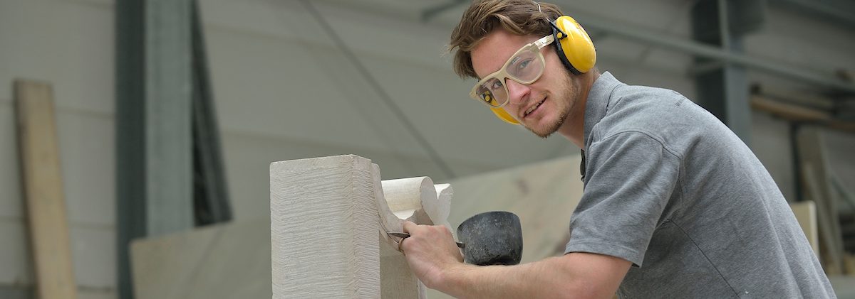 München, DEU, 12.05.2014 Steinmetz der Firma Steininger. Schlagwort(e): Werkstatt, Steinmetz formt Stein, Hammer, seitliche Positionieru